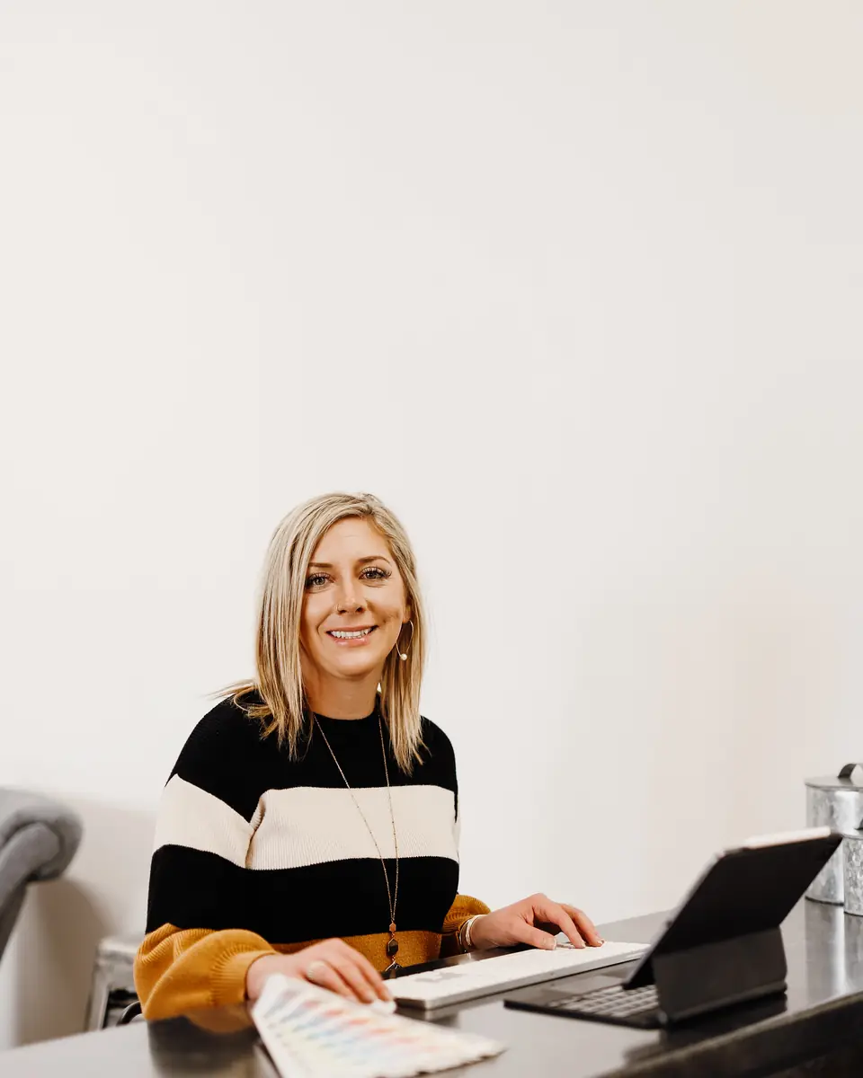 Ashlei working at her desk with a laptop