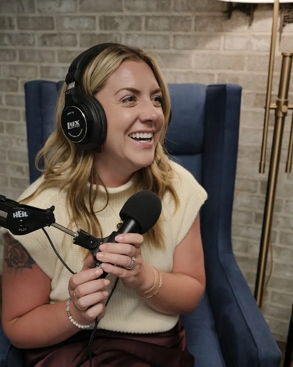 Ashlei in headphones, laughing at the microphone while recording HVAC Leaders