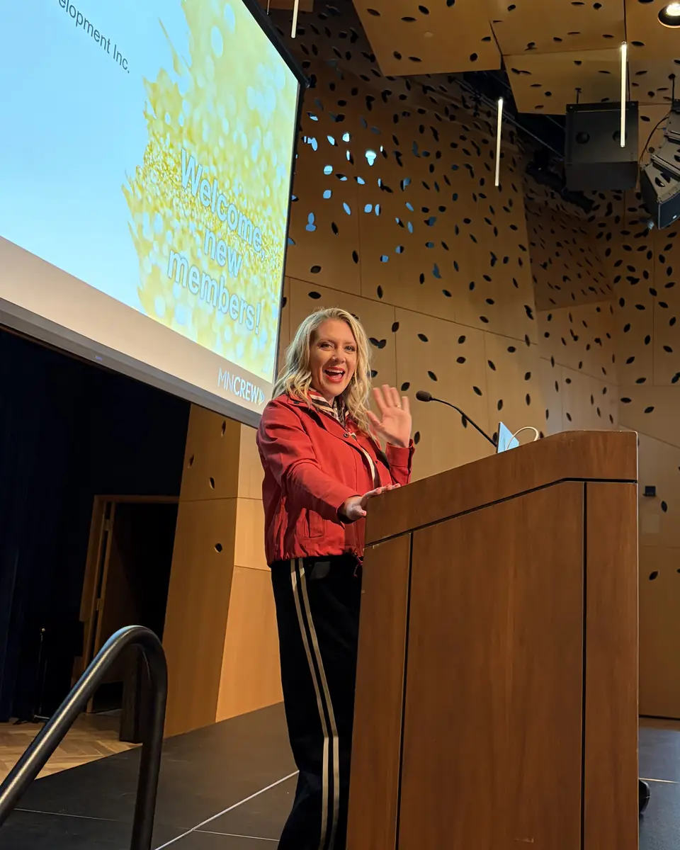 Ashlei mid-gesture at the podium during her MN CREW talk