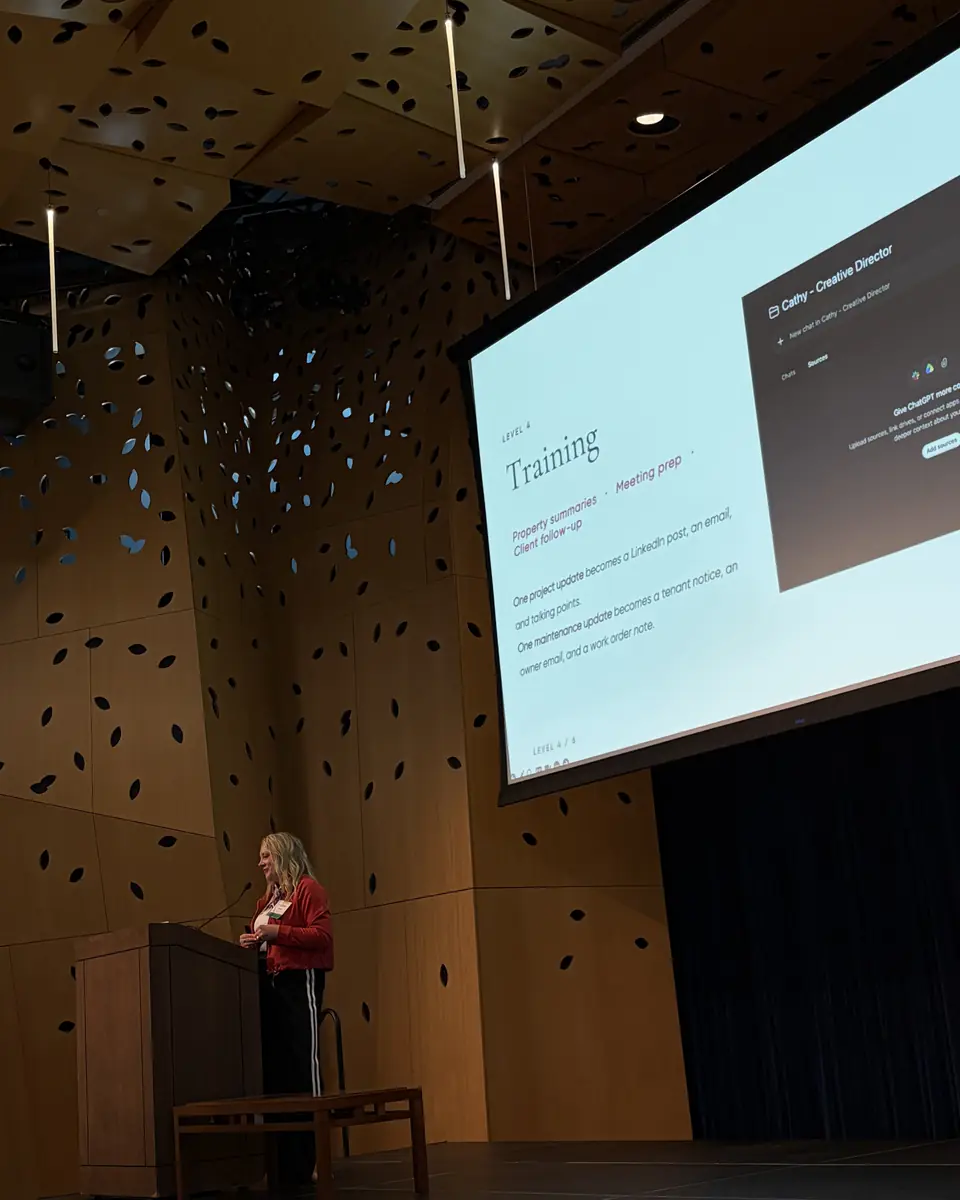 Ashlei at the podium in front of a slide on training your AI
