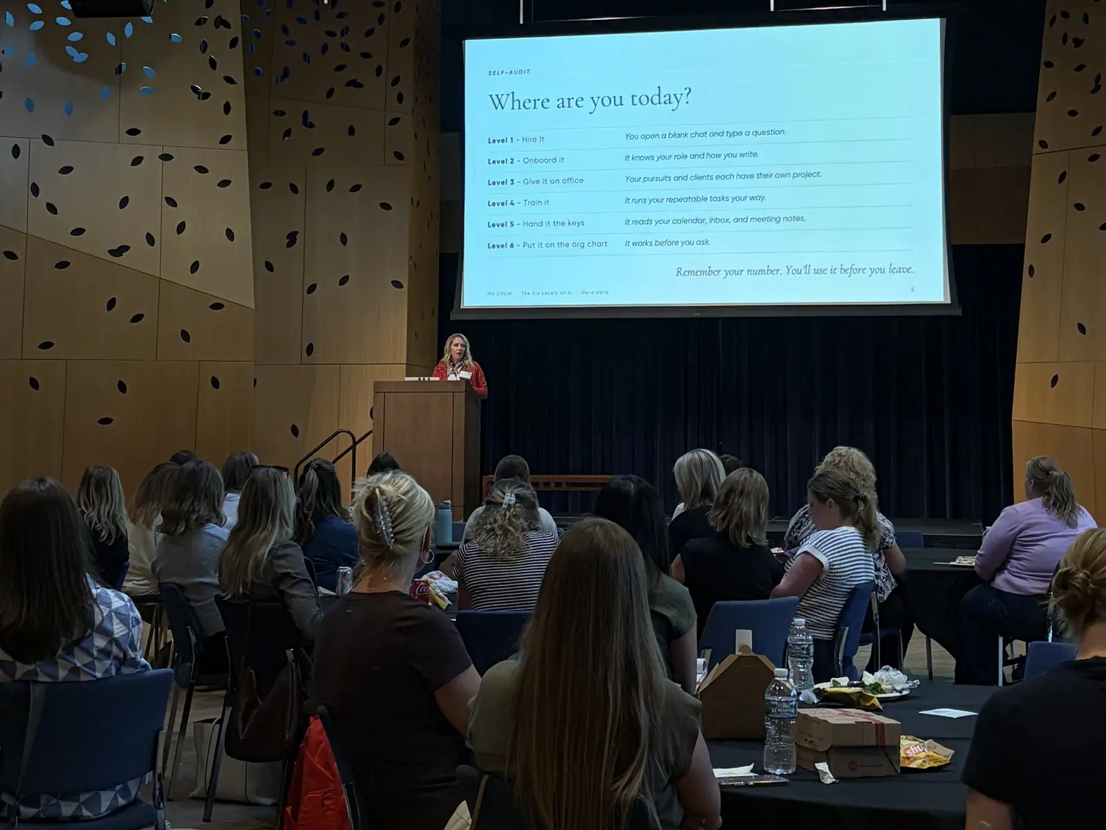 Ashlei speaking from the podium to a full room at the MN CREW monthly program